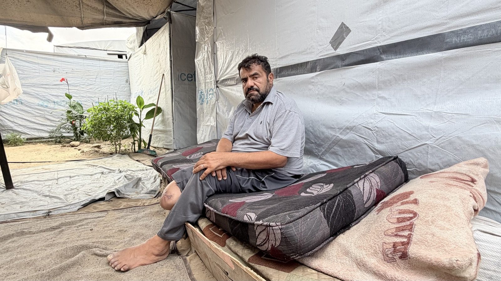 Ayad al-Jazzar sits on a mattress inside his tent in al-Mawasi