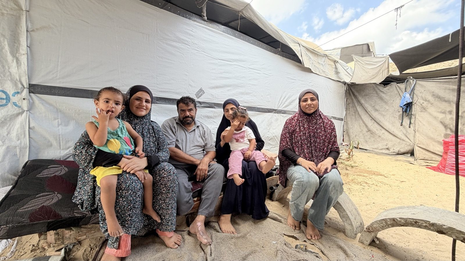 Ayad al-Jazzar with members of his family inside their tent