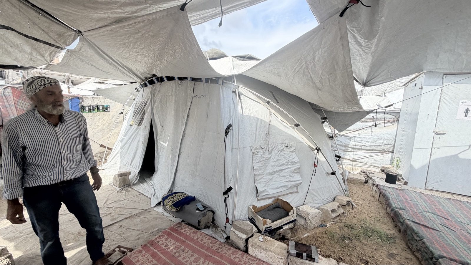 Muhammad Sa’dat walks between tents