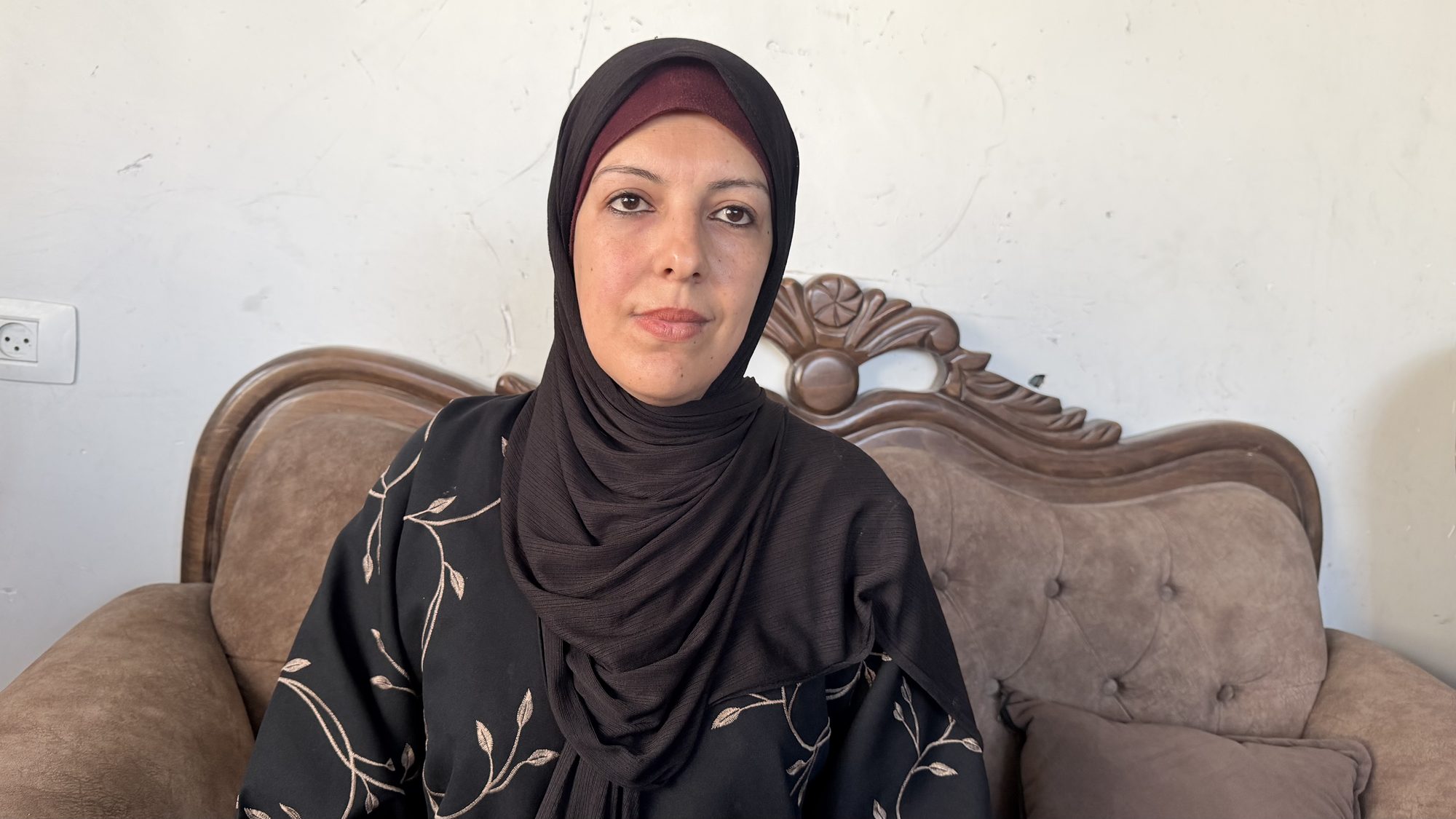 Mai al-Ghalban seated on a sofa